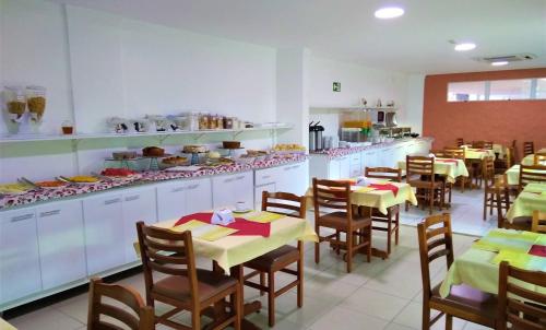 a dining room with tables and chairs in a restaurant at Simas Praia Hotel in Aracaju