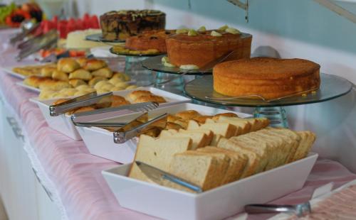 a table topped with different types of bread and pastries at Simas Praia Hotel in Aracaju