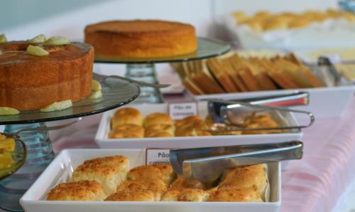 a display of different types of cakes and pastries at Simas Praia Hotel in Aracaju