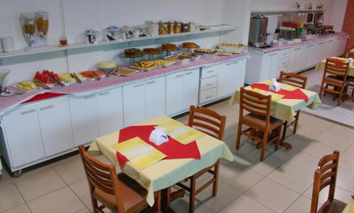 a restaurant with two tables and a counter with food at Simas Praia Hotel in Aracaju