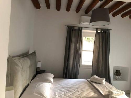 a bedroom with a bed with a lamp and a window at Chill out studio in the leafy Livadia village in Andros