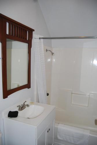 a white bathroom with a sink and a mirror at Deep Water Inn in Chelan