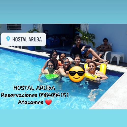 a group of people sitting in a swimming pool at Hostal Aruba in Atacames