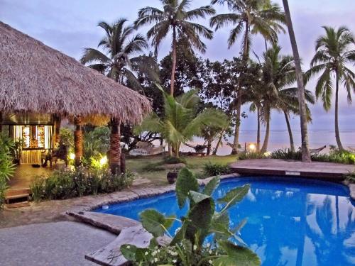a resort with a swimming pool and palm trees at Beachouse Resort in Namatakula