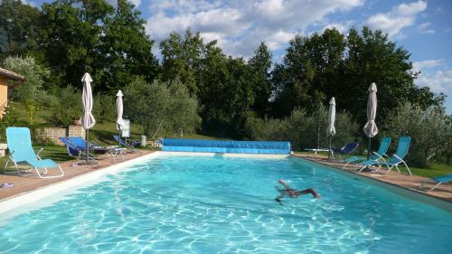 a person swimming in a large swimming pool at Il Bruco appartamenti in b&b in San Donato Val di Comino