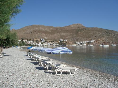 a row of beach chairs and umbrellas on a beach at Kleopatra's Rooms in Livadia