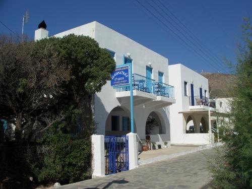 a white building with a blue sign in front of it at Kleopatra's Rooms in Livadia