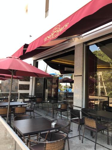 an outdoor patio with tables and chairs and umbrellas at Bissau Royal Hotel in Bissau