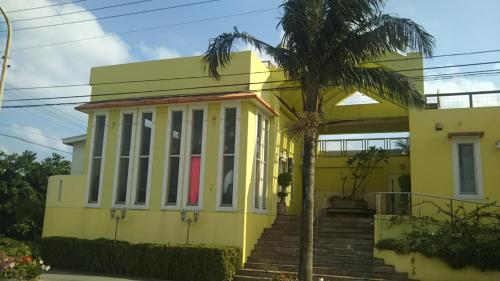 a yellow house with a palm tree in front of it at palmsﾌﾟﾗｲﾍﾞｰﾄﾌﾟｰﾙ,ﾐﾆﾋﾞﾘﾔｰﾄﾞ海と星空見える96平米 BBQ台 P1台分無料 wii WiFi in Ishigaki Island