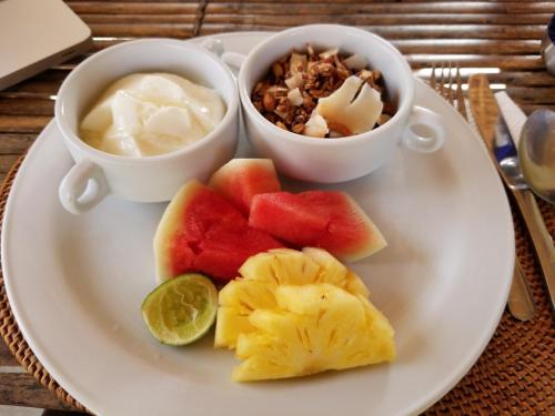 Ceningan Resort في نوسا ليمبونغان: طبق من الفاكهة مع صلصة التغميس وكوبين من الطعام