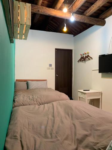 a bedroom with a bed and a table and a desk at Yamaharuka Historic House in Jinhu