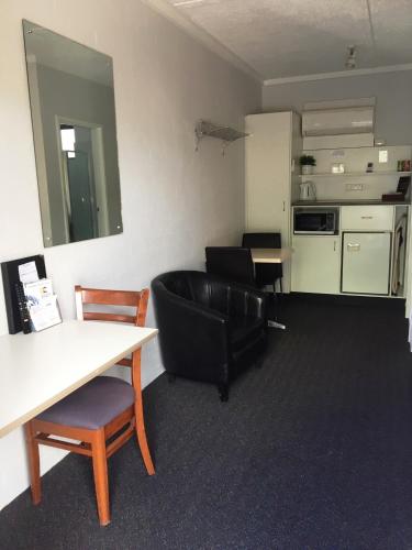 a living room with a table and chairs and a kitchen at Nicholas Royal Motel - No Pets Allowed in Hay