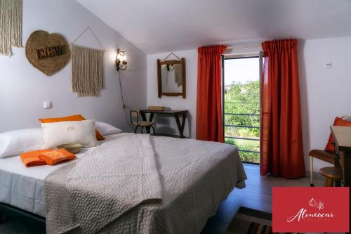 a bedroom with a bed and a window with red curtains at Guest House Almeixar in Almancil