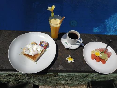 アメッドにあるVilla di Amedの2枚の皿に盛られた食べ物とコーヒーカップが置かれたテーブル