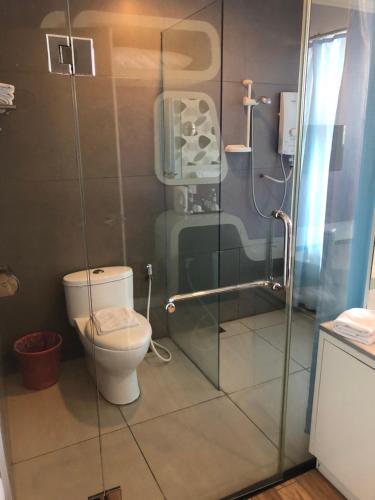 a bathroom with a toilet and a glass shower at King Park Hotel Tawau in Tawau