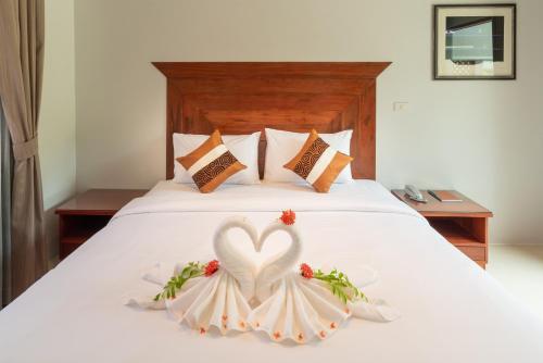 a bed with two swans made out of flowers at Wandee Garden in Choeng Mon Beach