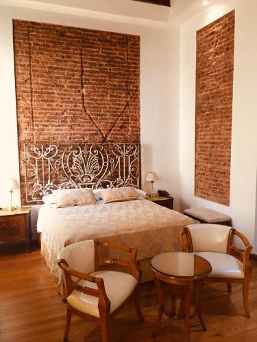 a bedroom with a bed and a brick wall at Hotel A&B Internacional in Buenos Aires