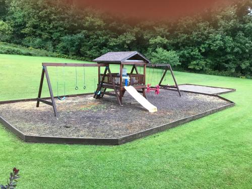 a playground with a swing in a yard at Coolis Apartment in Richfield Springs