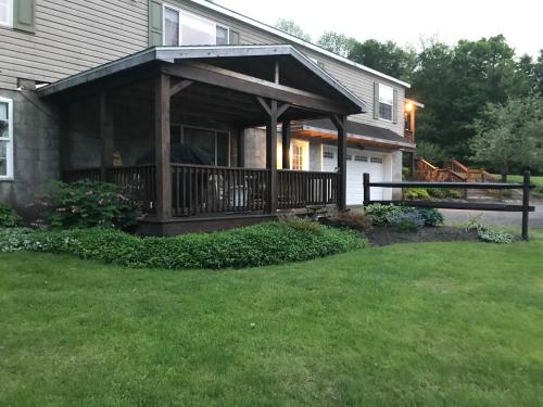 a house with a porch with a deck at Coolis Apartment in Richfield Springs