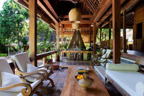 a living room with a couch and chairs on a porch at Kalapa Boutique Resort & Yoga in Canggu