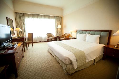 a hotel room with a bed and a television at Evergreen Laurel Hotel Penang in George Town