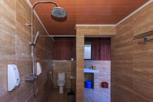 a bathroom with a toilet and a shower stall at Sylvia Beach Villa in Labuan Bajo