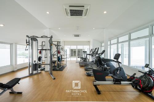 a gym with a row of treadmills and ellipticals at Rattanachol Hotel in Chon Buri