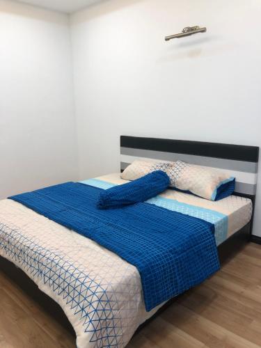a bed with a blue blanket on top of it at Home Suhaila in Kota Kinabalu