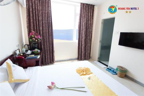 a hotel room with a bed and a tv and a window at Hong Phuc Hotel in Quy Nhon