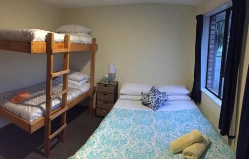 a bedroom with a bed and a bunk bed at Snow Denn Lodge in Methven