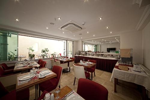 a restaurant with tables and chairs and a large window at Istanbul Newcity Hotel in Istanbul