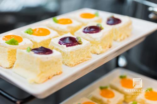a plate of food on a tray with desserts at Rattanachol Hotel in Chon Buri