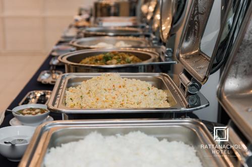 a row of trays filled with rice and food at Rattanachol Hotel in Chon Buri