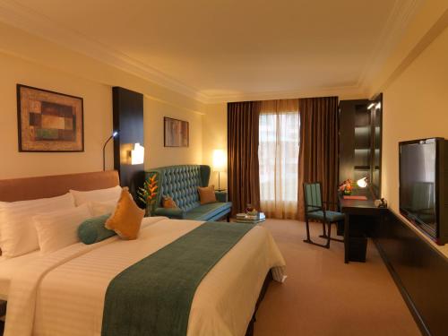 um quarto de hotel com uma cama e uma televisão em Sterlings Mac Hotel em Bangalore