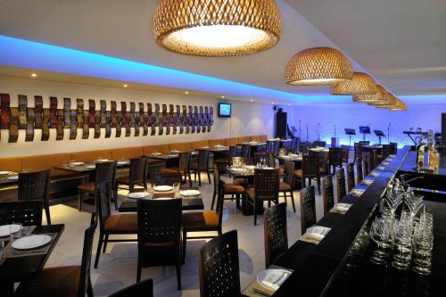 a restaurant with tables and chairs and a bar at Asiana Hotel Dubai in Dubai