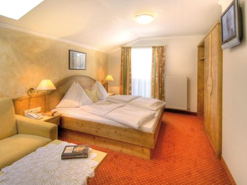 a bedroom with a large bed and a couch at Hotel Salzburger Hof in Dienten am Hochkönig