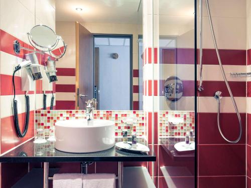 a bathroom with a sink and a shower at Mercure München City Schwabing in Munich