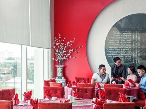 a group of people sitting at a table in a restaurant at Pullman Kuching in Kuching