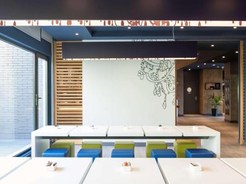 a conference room with white tables and blue chairs at Ibis Budget Madrid Calle 30 in Madrid
