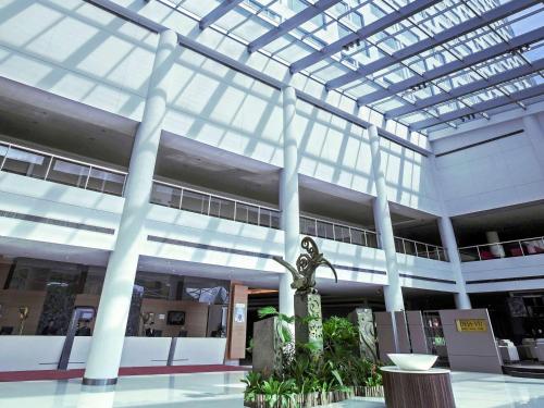 a large building with a glass ceiling and a statue at Pullman Kuching in Kuching