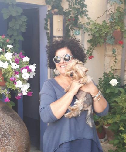 a woman holding a dog in her hands at Ble Mavi - Studio for 2 in Vouni