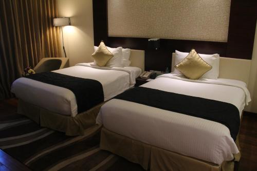 two beds in a hotel room with white and black sheets at Howard Johnson By Wyndham, Hebbal, Bengaluru in Bengaluru