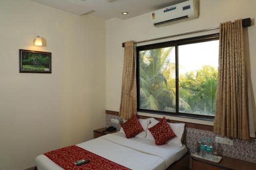 a bedroom with a bed and a large window at Hotel Sai Grand Castle Inn in Shirdi