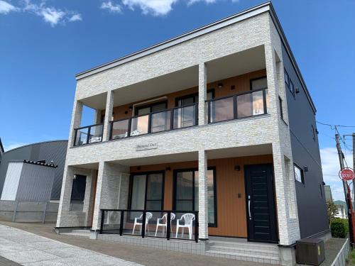 a building with two chairs sitting on the balcony at Diamond Dust Furano in Furano
