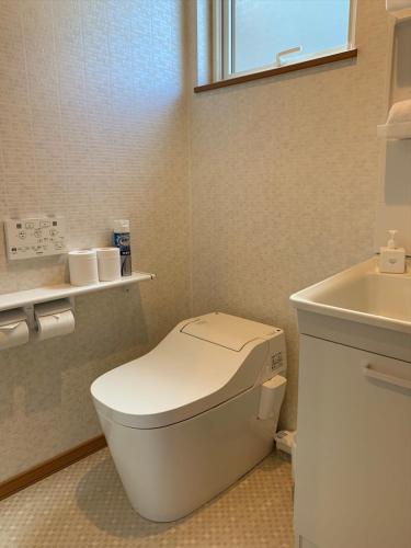a small bathroom with a toilet and a sink at Diamond Dust Furano in Furano