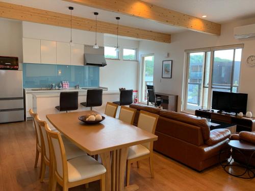 a kitchen and living room with a table and a couch at Diamond Dust Furano in Furano