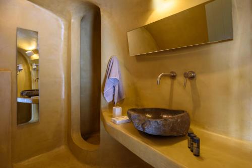 a bathroom with a stone sink on a counter at Sublime Villa & Caves in Akrotiri