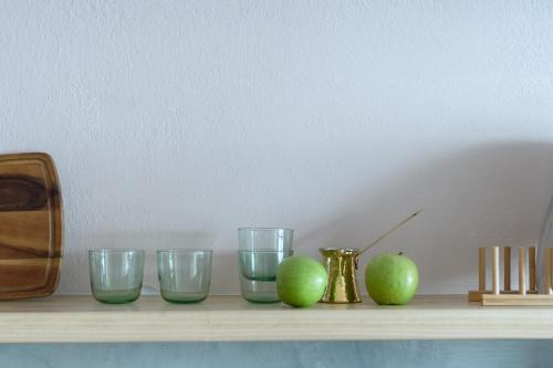 a shelf with three glasses and three apples on it at Sublime Villa & Caves in Akrotiri