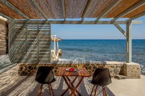a table and two chairs in front of the ocean at Sublime Villa & Caves in Akrotiri
