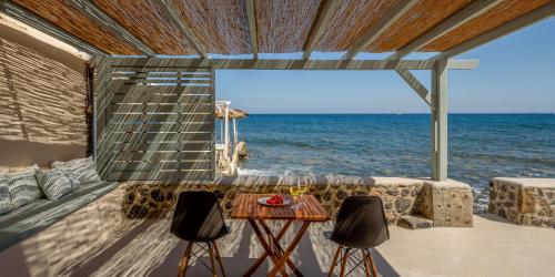 a room with a table and chairs and the ocean at Sublime Villa & Caves in Akrotiri